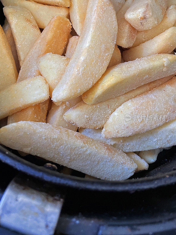 冰冻薯条/大块薯条在空气炸锅煮，更健康的零食烹饪选择，从高处看，关注前景